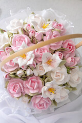 Zephyr bouquet of flowers in a wicker basket on a light background