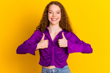 Photo portrait of pretty young girl show thumb up wear trendy violet outfit isolated on yellow...