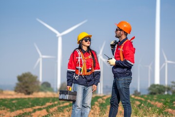 couple engineer team inspection check control wind power machine construction installation in wind...