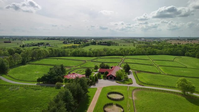 Hovering over barns dedicated to thoroughbred horses, encircled by fenced pastures and racing training grounds in the countryside of central Kentucky.