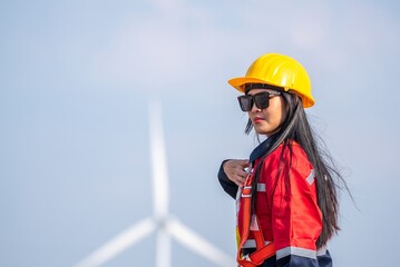Woman engineer inspection posing check control wind power machine in wind energy factory at...