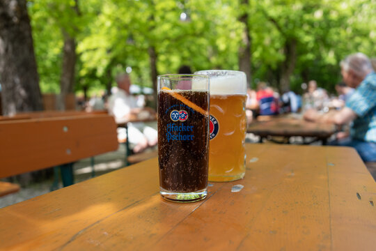 Erfrischende Pause im Biergarten: Spezi und Bier genie&szlig;en unter M&uuml;nchens gr&uuml;nen B&auml;umen