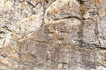 A rock wall with a lot of cracks and holes