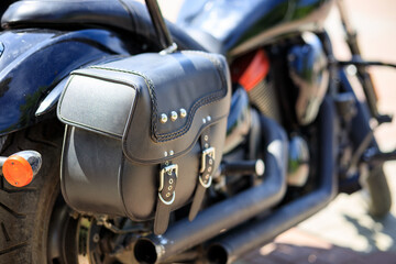 A black motorcycle with a leather bag on the back