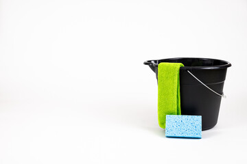 Black cleaning bucket with sponge and wash rag.
