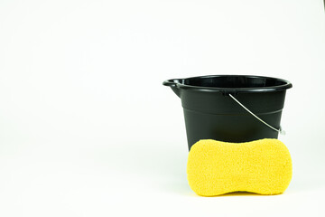 Black cleaning bucket with sponge and wash rag.