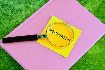 Membership text. Concept image. MEMBERSHIP word written through a magnifying glass on a yellow...