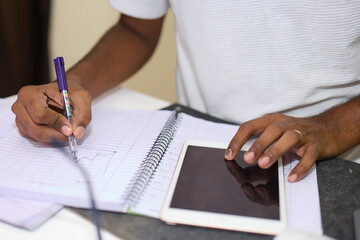 Close up of a man writing in a notebook with a pen