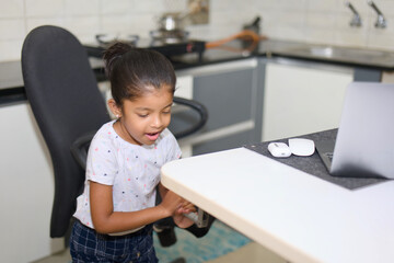 Independent Child Adjusting Laptop Stand in Kitchen