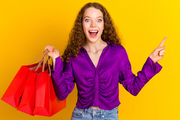 Photo portrait of lovely young lady hold shopping bags point empty space dressed stylish violet...