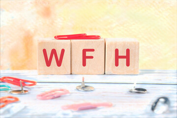 Work From Home. New business concept. Letters WFH on wooden cubes on a bright and beautiful...