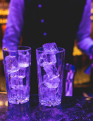 Bartender working, beautiful row line of different coloured liquor alcohol cocktails on a party in a bar, and others on catering banquet on event, barman mixing drinks and beverages in a club