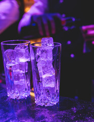 Bartender working, beautiful row line of different coloured liquor alcohol cocktails on a party in a bar, and others on catering banquet on event, barman mixing drinks and beverages in a club