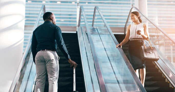 Business people, greeting and escalator with luggage at airport for work trip, travel or opportunity. Happy businessman and woman talking on electric staircase or lift for immigration with bags