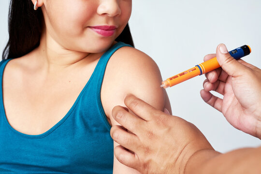 Hands, girl or insulin shot in healthcare for blood sugar levels, glucose or energy for body. Young kid, child and injection for weight loss on white background, diabetes or medical treatment