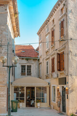 Rovinj, Croatia. Picturesque Mediterranean street with outdoor cafes people walking summer sun.