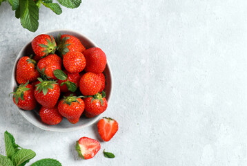 organic strawberries in a bowl on a gray background