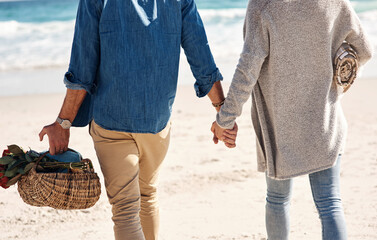 Couple, beach and holding hands or walking on holiday for vacation at ocean or sea with love....
