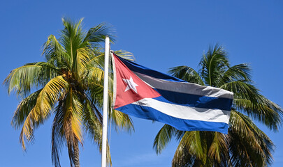 Cuban flag against a background of palm trees and blue sky