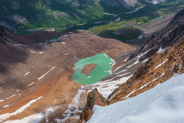Scenic aerial top view to most beautiful turquoise glacial lake with stony islet in hanging valley...