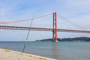 Ponte 25 de abril, 25h april bridge with a fishing rod by the river