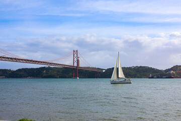 boat over the river by ponte 25 de abril of lisbon