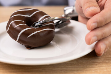 A man is handcuffed to a chocolate donut. Passion for sweets.