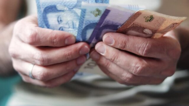 Hand holding Moroccan banknotes, dirham official currency of Morocco.