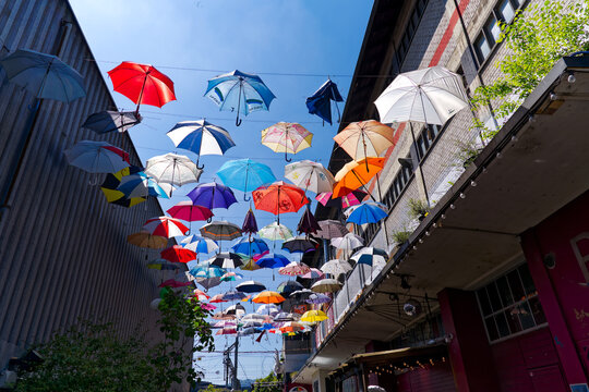 Looking up decoration of colorful hanging umbrellas at terrace of Restaurant named Gerold Chuchi at Swiss City of Z&uuml;rich on a sunny spring noon. Photo taken May 10th, 2024, Zurich, Switzerland.