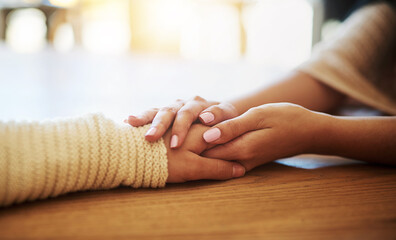 Support, care and women holding hands on table for sympathy, comfort and compassion with grief....