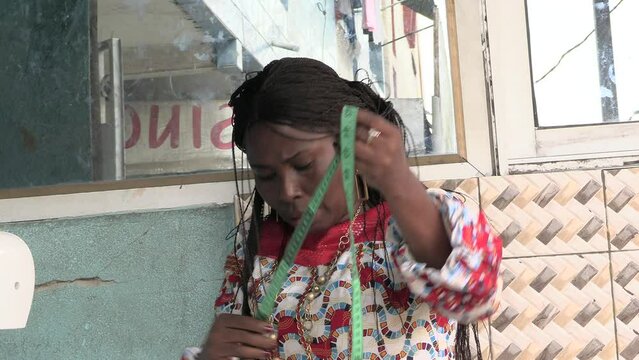 close up of a beautiful mature woman checking her tape measure, smiling.