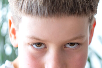 close-up eyes, caucasian child, aggressive boy looking sideways, negative emotions, rebellious...
