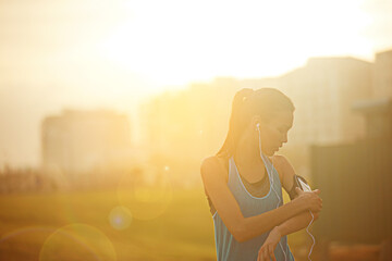 Woman, runner and phone with earphones for exercise with thinking, subscription or buildings in city. Girl, person and athlete at training, workout and sound for music streaming with choice on app