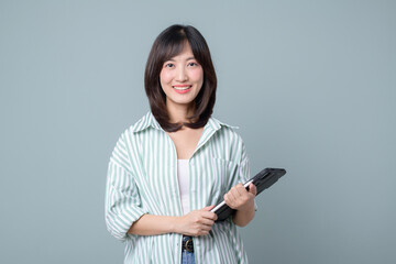 young enterpriser manager, asian working woman holding tablet and smiling, standing over green...