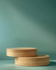 Two round wooden pedestals are stacked against a simple teal background in a minimalist composition. Product podiums - 811150449