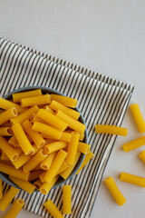 Dry Rigatoni Pasta in a Bowl, top view. Flat lay, overhead, from above. Copy space.