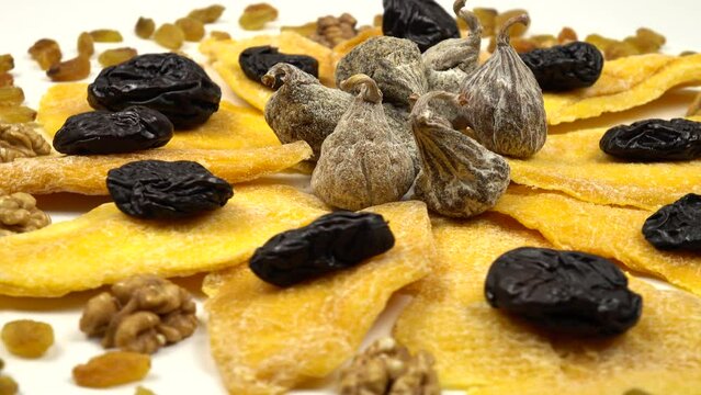 Composition of dried fruits and nuts in the shape of a flower. Dried mango slices, prunes and figs, raisins and peeled walnut kernels, natural background