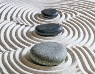 Traditional Japanese dry sand and stone zen garden. Closeup of patterns on white sand and round black ornamental pebbles. 
