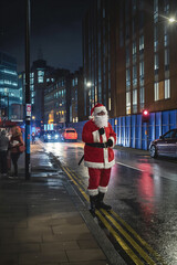 Urban Santa Claus Waiting at the Sidewalk by Night