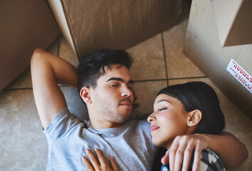 Couple, rest and relax on floor in new home with boxes for property investment and moving day for...
