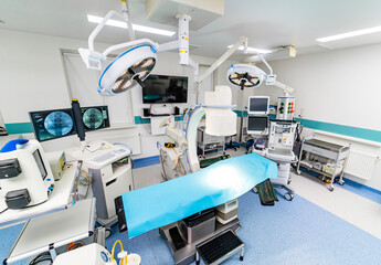 A hospital room with a blue bed and a monitor. The room is clean and well-lit