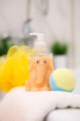 Children's bath accessories, shampoo tube, spa bath bombs with children's cosmetics on background of modern bath. Caring for and caring for children. Place for text. Vertical image.