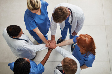 Top view, teamwork or hands of doctors in stack with mission in collaboration for healthcare support. Hospital clinic, people or group of medical nurses with solidarity, motivation or community help