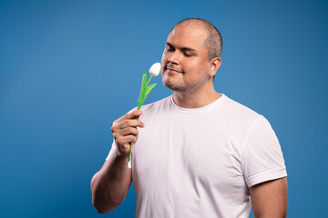 man smelling a flower