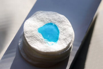 A sponge with a transparent blue gel applied to it. Close-up. Blurred background.