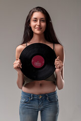 Skinny woman displays vinyl, flat belly evident