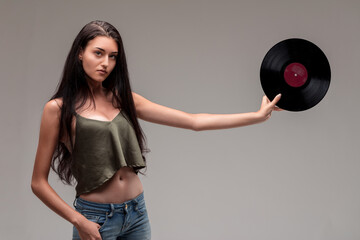 Poised young woman elegantly displays vinyl LP