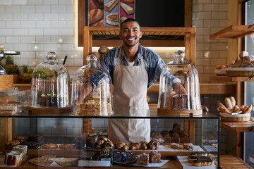 Coffee shop, portrait and happy man waiter in bakery for store welcome, help and friendly hospitality service. Retail, startup and cafe or restaurant server with cake, cookies or counter assistance