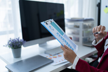 Young business sitting at the table and working with a computer, documents and calculator