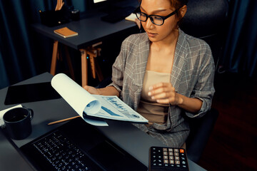 Businesswoman looking outside with thinking report data analysis overworked project job while...